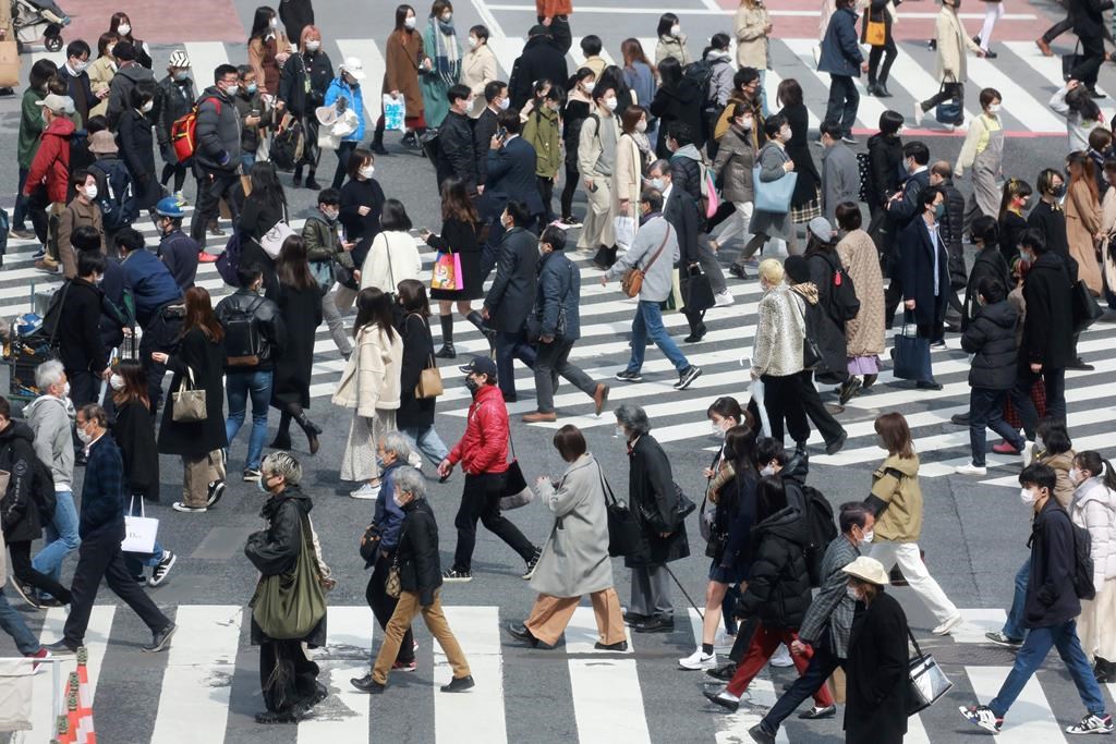 People cross a scramble intersection in Tokyo on Tuesday, March 9, 2021