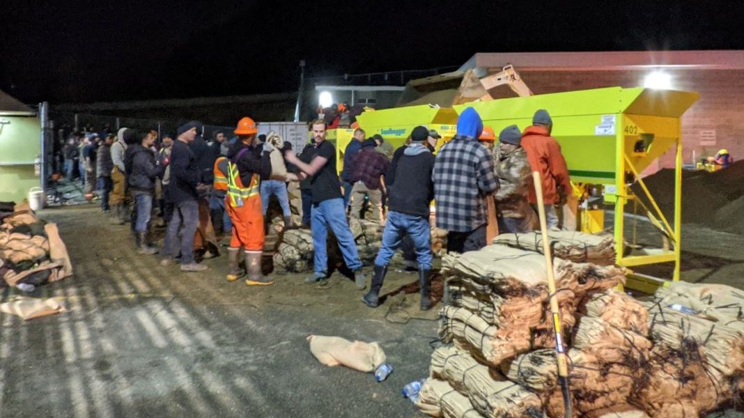 People stand in a line to help fill sandbags
