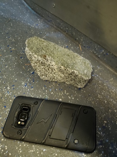 A rock is seen next to a smart phone for size comparison