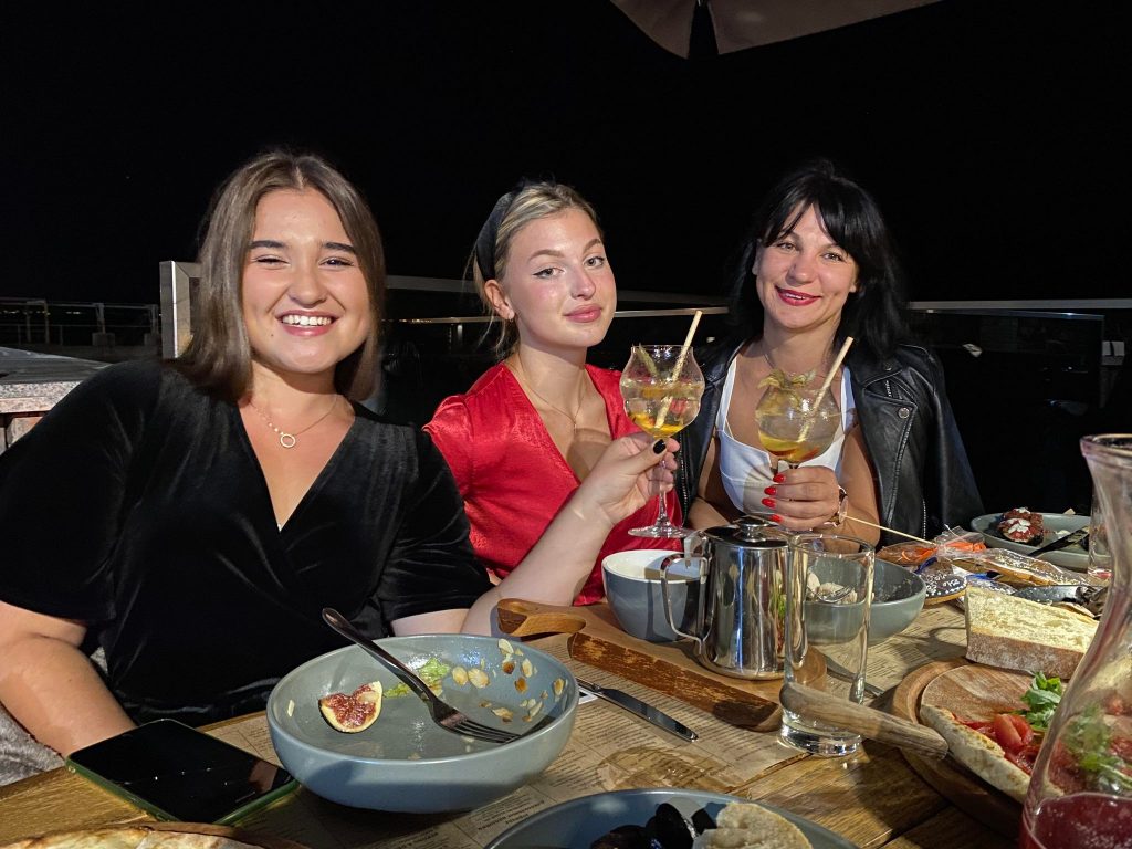 A picture of three women having dinner. The women all want to come to Canada due to the Russia-Ukraine crisis.
