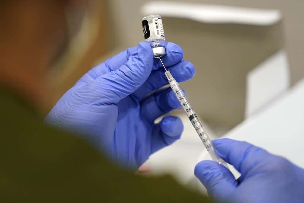 A healthcare worker fills a syringe with the Pfizer COVID-19 vaccine at Jackson Memorial Hospital on Oct. 5,