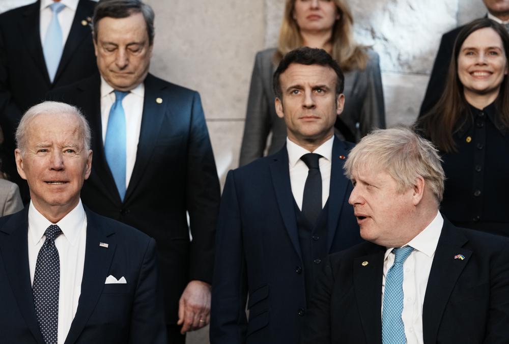 British Prime Minister Boris Johnson, front right, looks toward U.S. President Joe Biden, front left, at a group photo during an extraordinary NATO summit at NATO headquarters in Brussels, Thursday, March 24, 2022. As the war in Ukraine grinds into a second month, President Joe Biden and Western allies are gathering to chart a path to ramp up pressure on Russian President Vladimir Putin while tending to the economic and security fallout that's spreading across Europe and the world. British Prime Minister Boris Johnson, front right, looks toward U.S. President Joe Biden, front left, at a group photo during an extraordinary NATO summit at NATO headquarters in Brussels, Thursday, March 24, 2022. As the war in Ukraine grinds into a second month, President Joe Biden and Western allies are gathering to chart a path to ramp up pressure on Russian President Vladimir Putin while tending to the economic and security fallout that's spreading across Europe and the world.