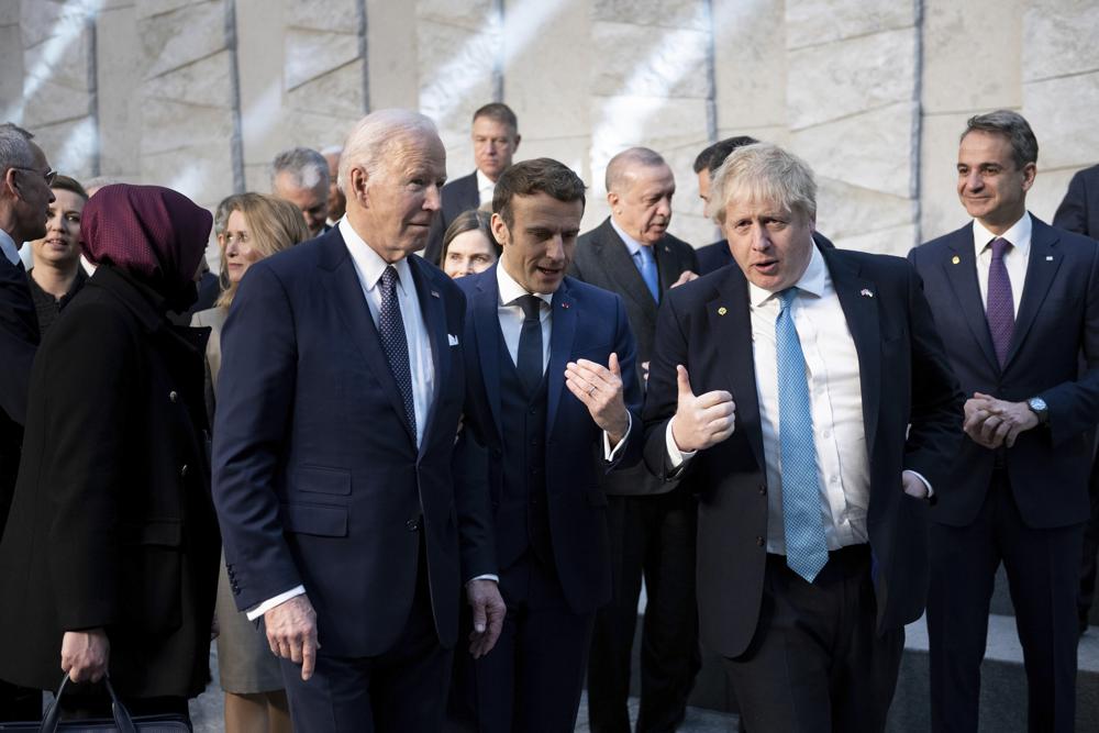 President Joe Biden, left, talks with French President Emmanuel Macron and Briitish Prime Minister Boris Johnson, right, as they arrive at NATO Headquarters in Brussels, Thursday, March 24, 2022. President Joe Biden, left, talks with French President Emmanuel Macron and Briitish Prime Minister Boris Johnson, right, as they arrive at NATO Headquarters in Brussels, Thursday, March 24, 2022.
