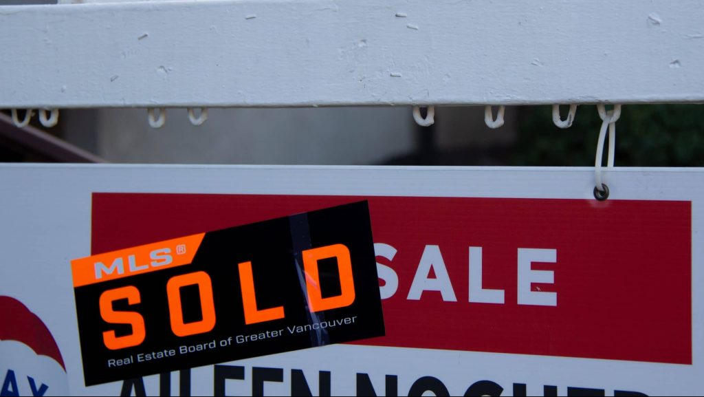 A SOLD sticker on a For Sale sign in Metro Vancouver.