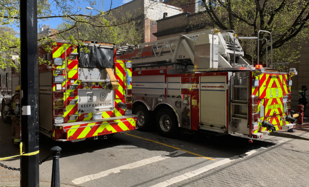Two Vancouver fire trucks parked in a roadway after flames broke out in a Gastown building