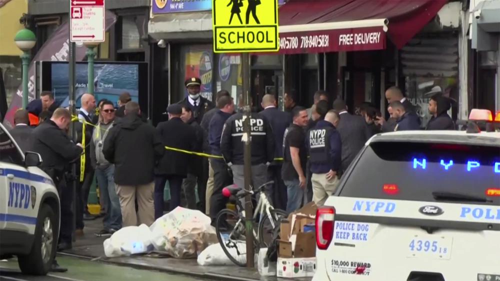 A group of New York police officers and first responders gather after a Brooklyn subway station shooting