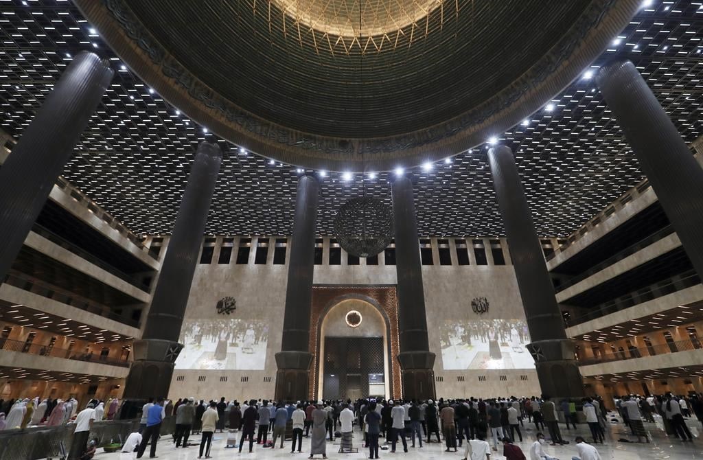 Indonesian Muslims pray spaced apart as they practice social distancing to curb the spread of the new coronavirus during an evening prayer called "tarawih" marking the first eve of the holy fasting month of Ramadan at Istiqlal Mosque in Jakarta, Indonesia. Monday, April 12, 2021. During Ramadan, the holiest month in Islamic calendar, Muslims refrain from eating, drinking, smoking and sex from dawn to dusk. (AP Photo/ Achmad Ibrahim)