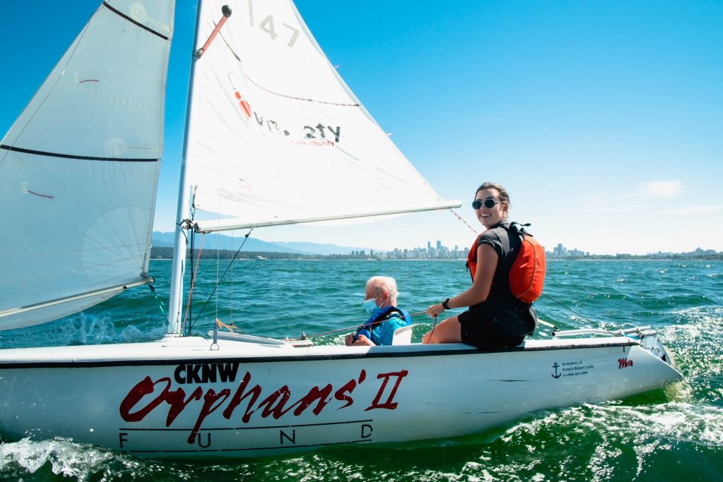 A photo of two people sailing in Vancouver as part of a program that offers adaptive sailing for all levels and abilities