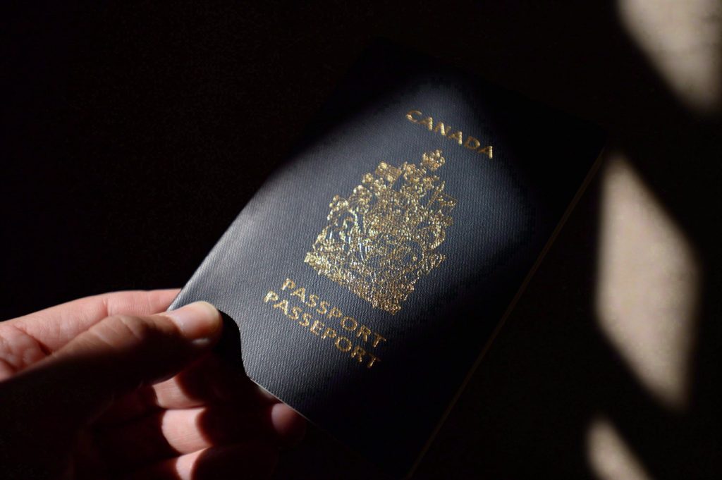 A Canadian passport is held by a person