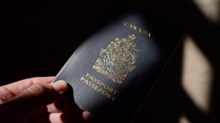 A Canadian passport is held by a person