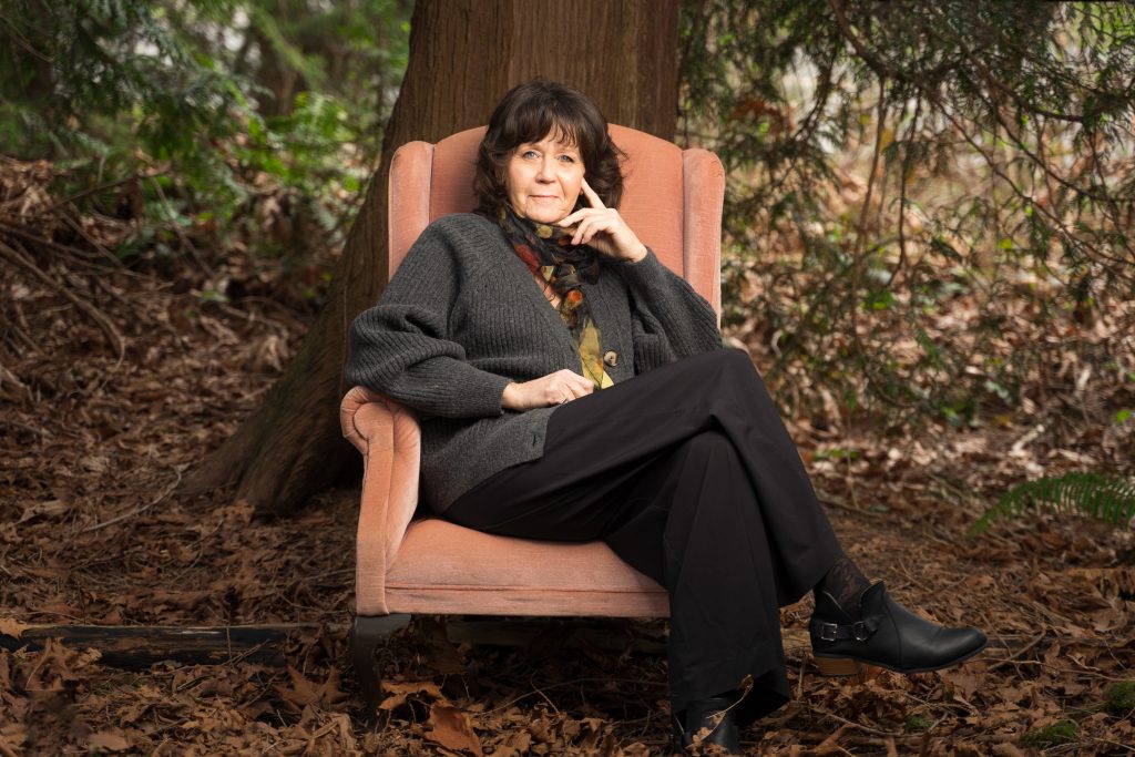 Bernadine Fox, the recipient of the Courage To Come Back award in the Mental Health category, sits in a pink chair outside, her legs crossed and her left arm up to her face