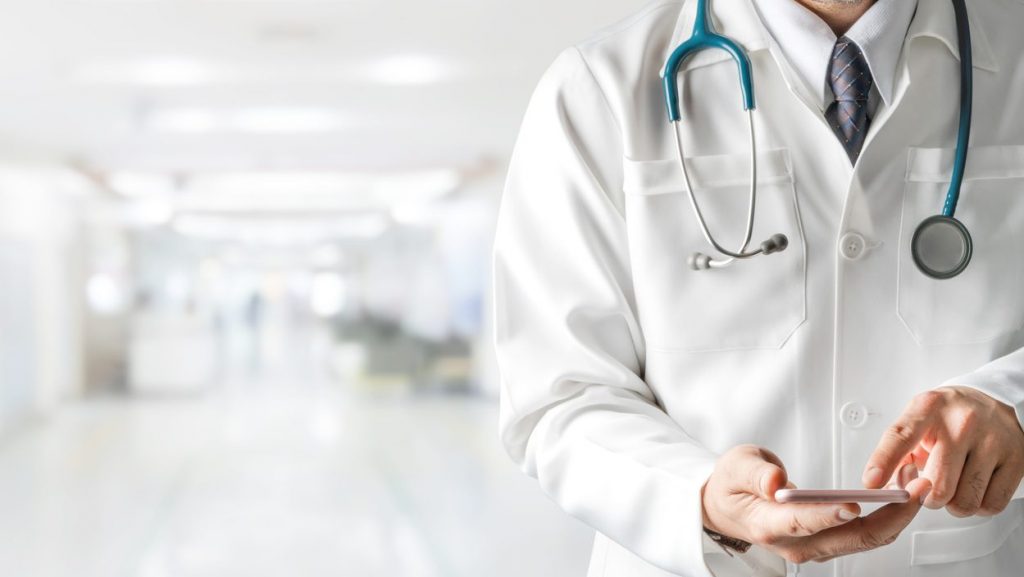 Male doctor using mobile phone at hospital