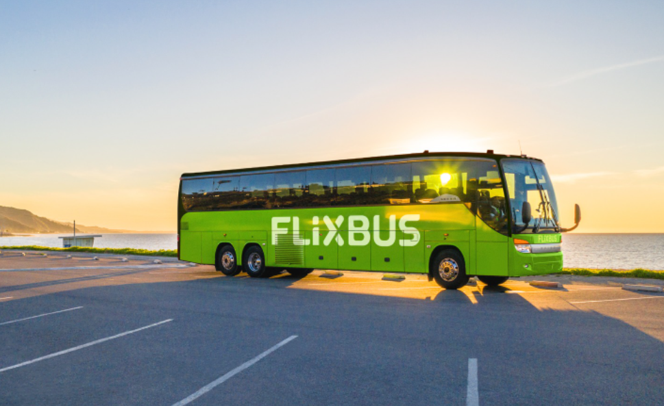 A FlixBus bus is pictured in a parking lot near the shoreline