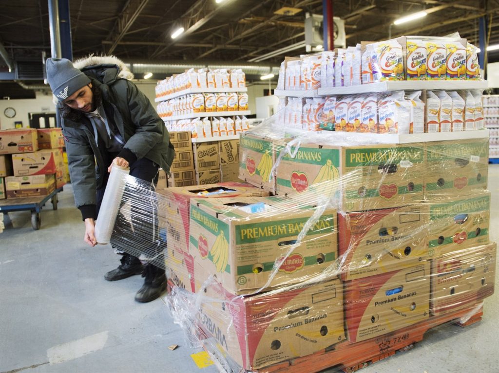 FILE - Artem Mousessian wraps a shipment for delivery at the distribution centre for Moisson Montreal, the largest food bank in Canada, Thursday, January 28, 2016 in Montreal. THE CANADIAN PRESS/Ryan Remiorz