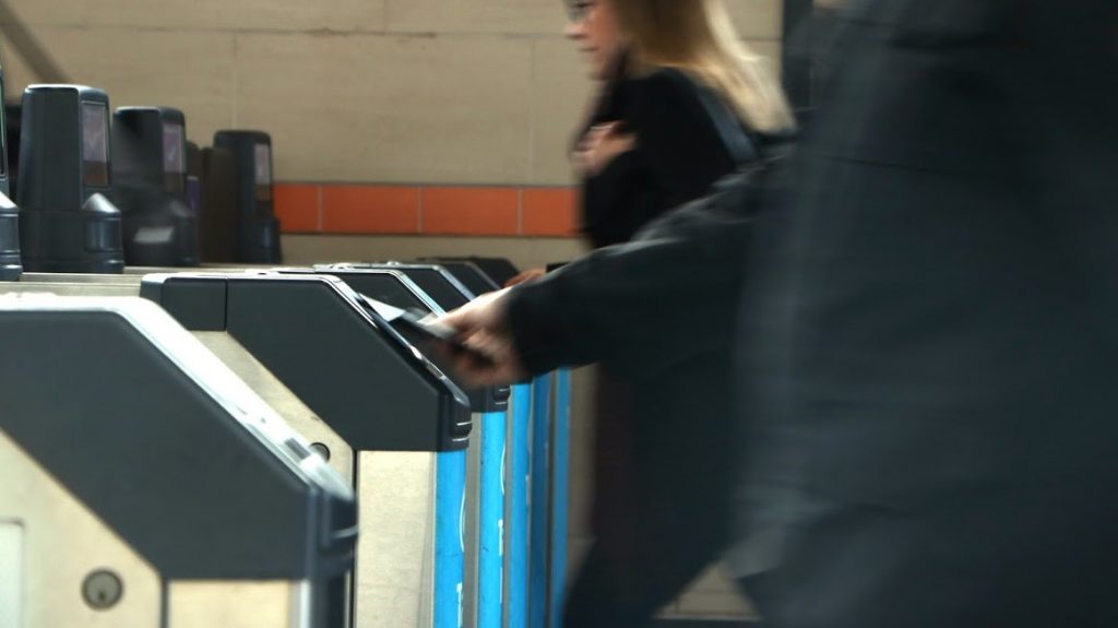 A person taps a Compass Card at a SkyTrain gate