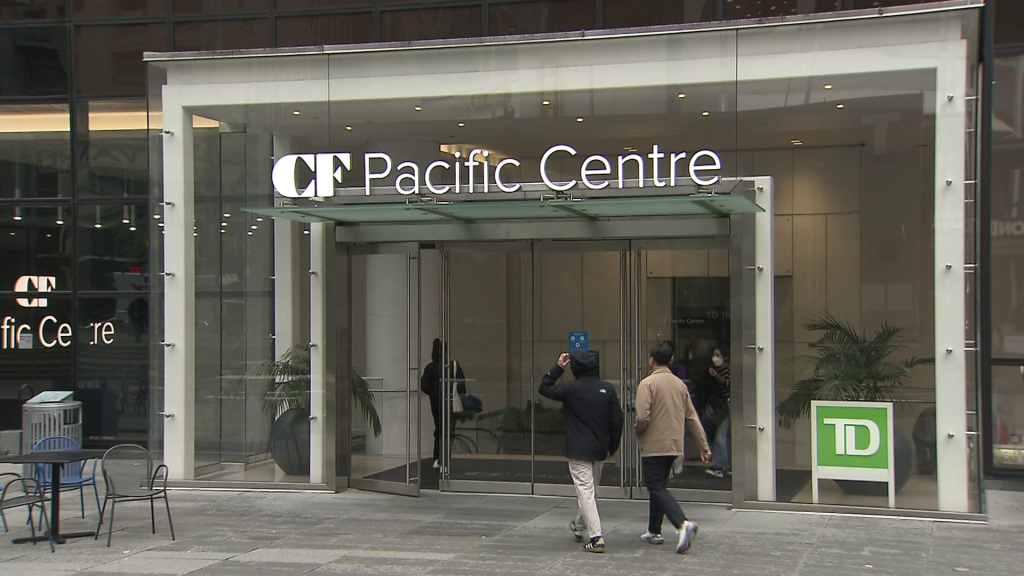 People walk to the Pacific Centre Mall entrance