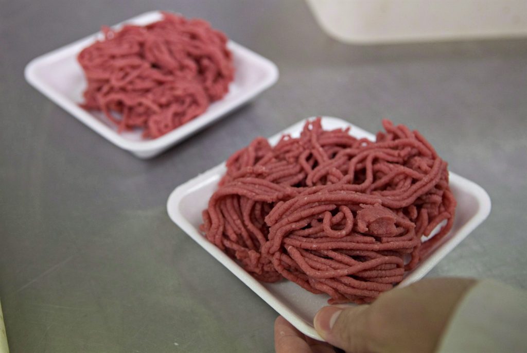 Fresh ground beef is packed at a butcher shop