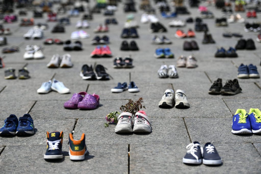 Dried flowers rest inside a pair of child's running shoes at a memorial for the 215 children whose remains were found at the grounds of the former Kamloops Indian Residential School at Tk’emlups te Secwépemc First Nation in Kamloops, B.C., on Parliament Hill in Ottawa on Friday, June 4, 2021. THE CANADIAN PRESS/Justin Tang