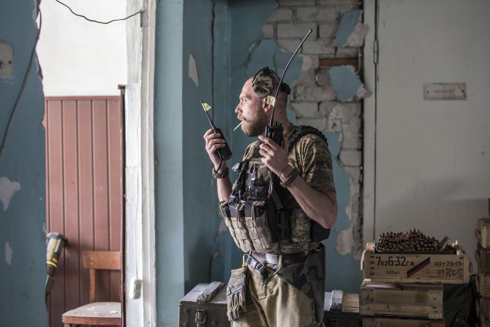 Ukrainian soldier holds radios during heavy fighting