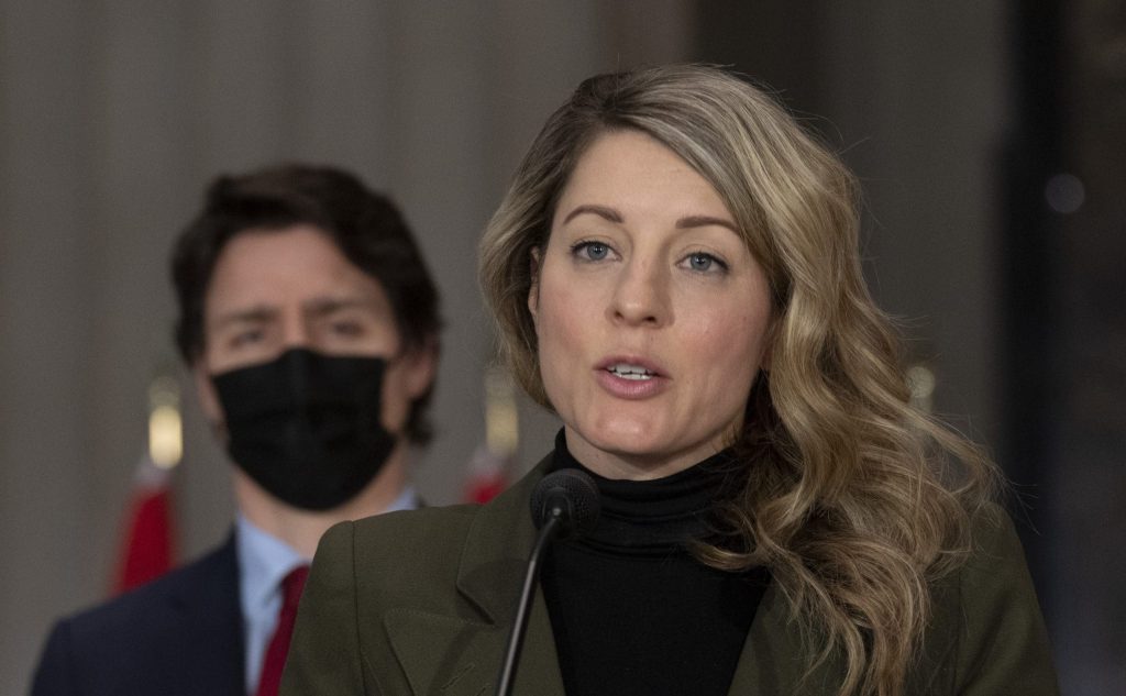 Canadian Prime Minister Justin Trudeau looks on as Foreign Affairs Minister Melanie Joly responds to a question during a news conference