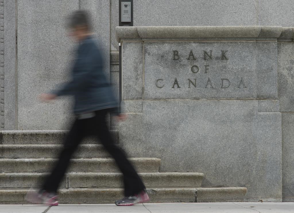 A woman walks past the Bank of Canada building, in Ottawa