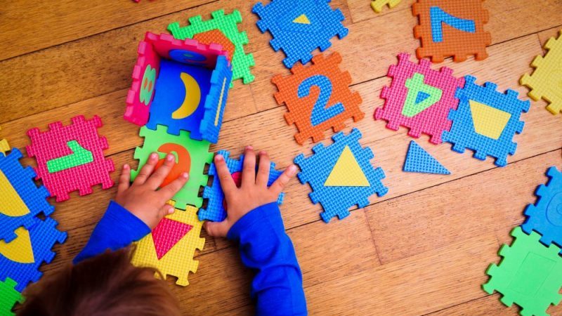 A young child plays with colourful toys on the ground. (iStock Photo)