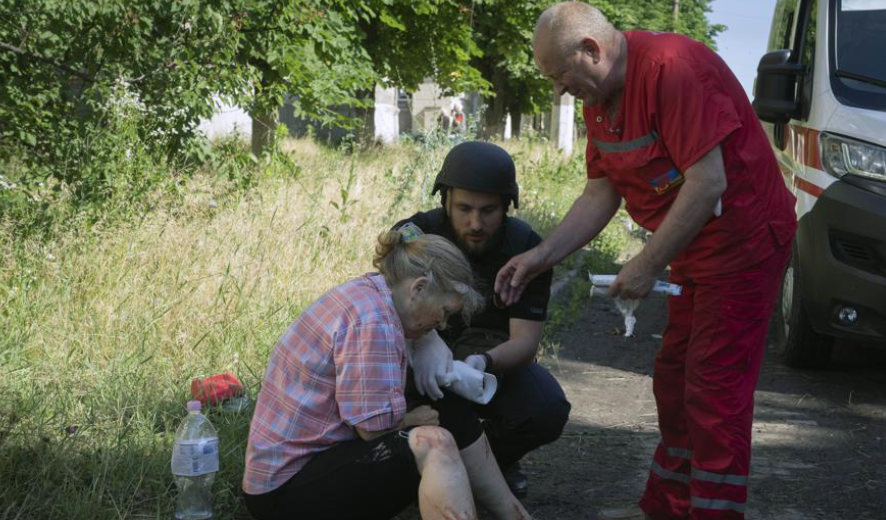 A police officer and paramedic give the first aid to a woman wounded by the Russian shelling in city center in Slavyansk, Donetsk region, Ukraine, Monday, June 27, 2022. (AP Photo/Efrem Lukatsky)
