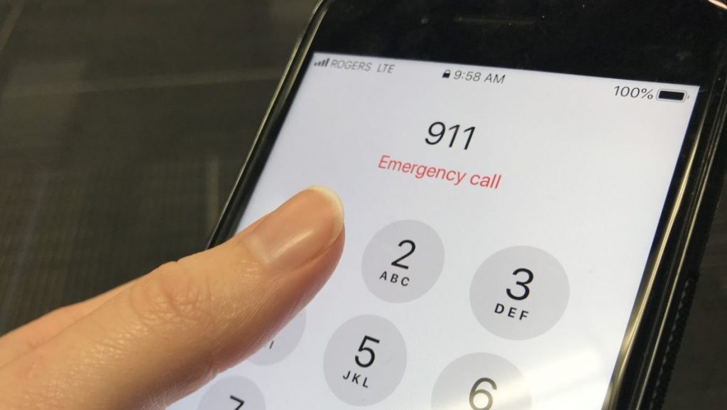 A finger taps the numbers 9-1-1 on a smart phone