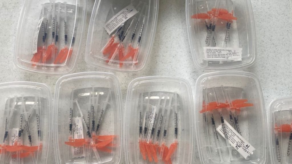 Boxes filled with vaccines sit on a table