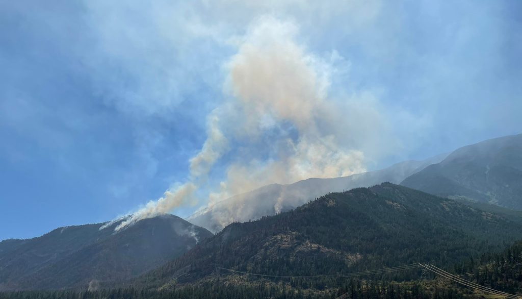 Smoke is seen rising from a mountaintop as little fires burn in a forested area