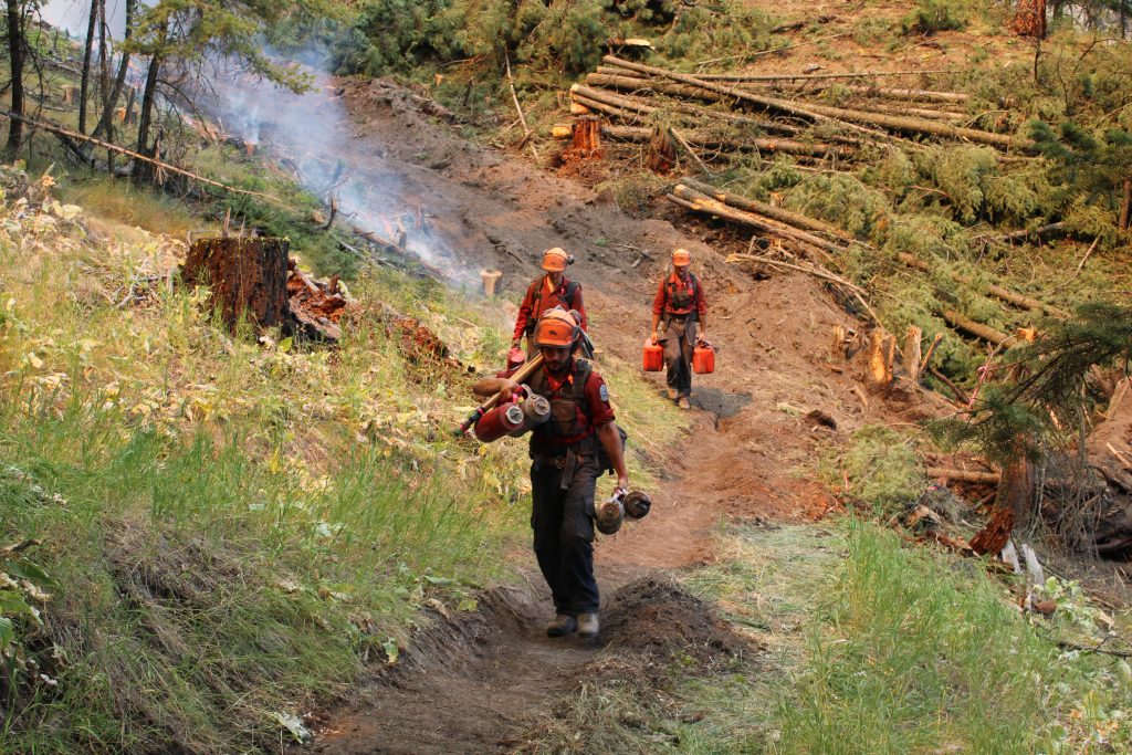 Firefighters hike the east flank of the Keremeos Creek Wildfire