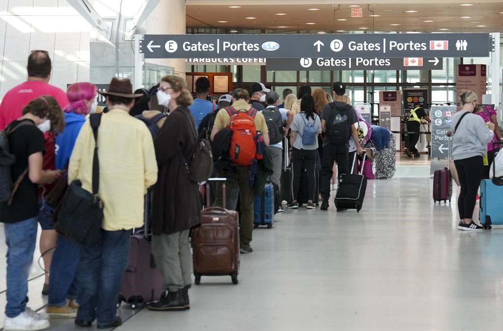 People line up before entering the security at Pearson International Airport in Toronto