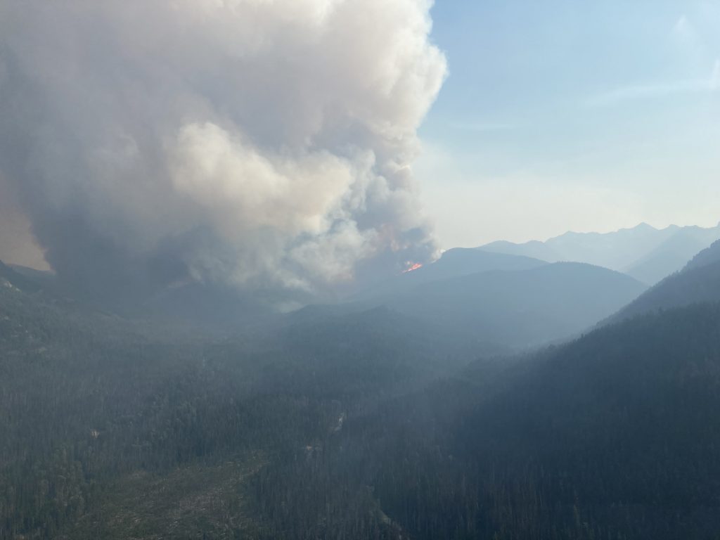 An aerial shot of the Heather Lake Wildfire that has large plumes of smoke rising into the sky