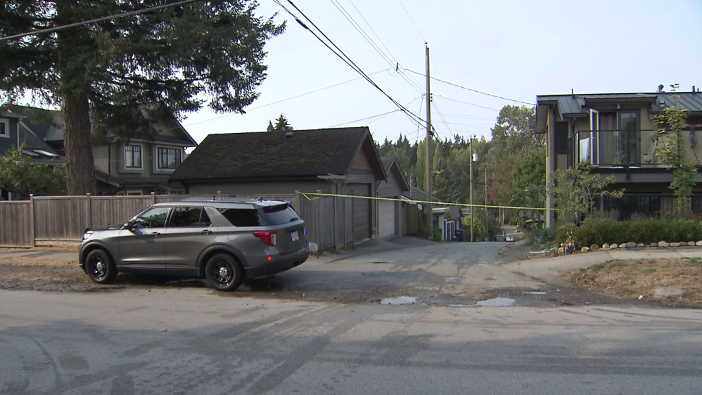 A burnt out car sits in a Vancouver alleyway