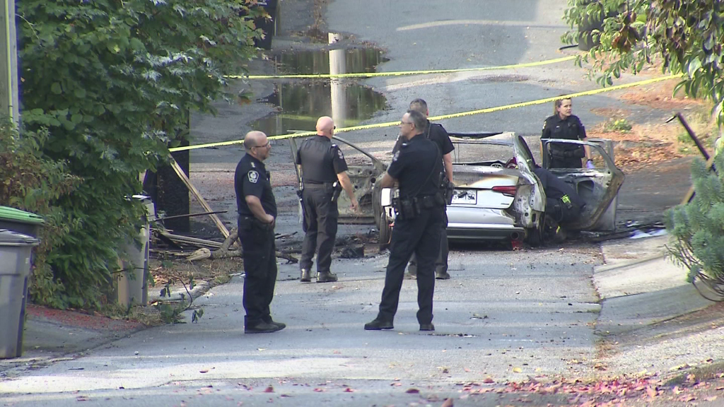 A burnt out car sits in a Vancouver alleyway