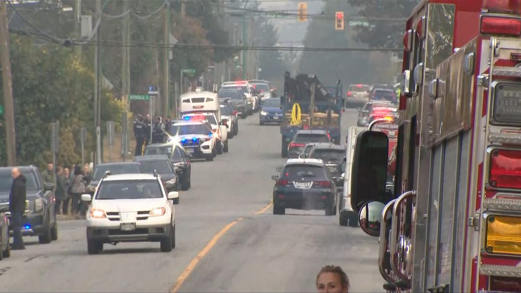 Police cars and officers line a street during a procession for Burnaby RCMP Const. Shaelyn Yang, who was killed in the line of duty