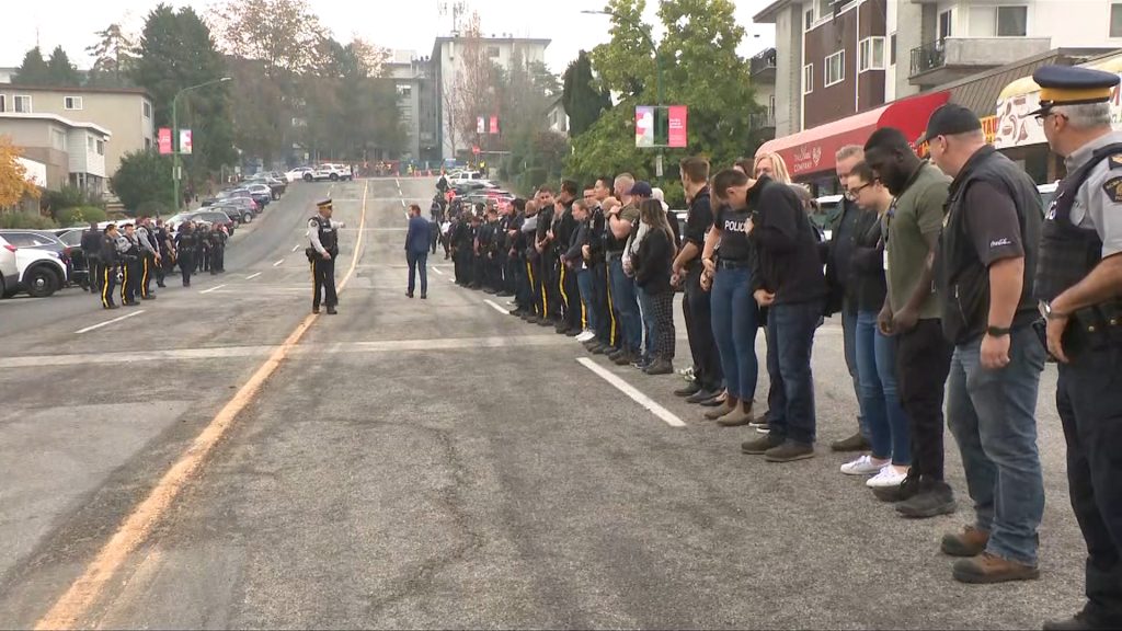 Police cars and officers line a street during a procession for Burnaby RCMP Const. Shaelyn Yang, who was killed in the line of duty