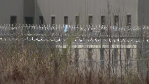 barbed wire lines the fence outside of prison