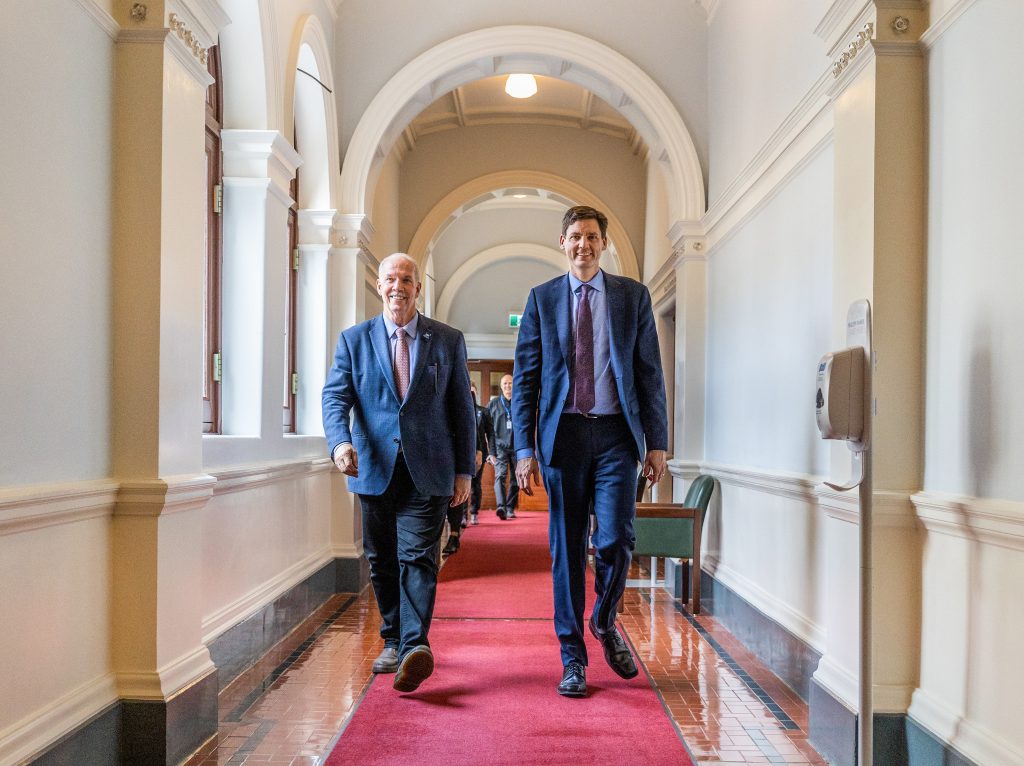 John Horgan and David Eby walk down a hall