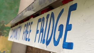 sign that reads the community free fridge in blue paint