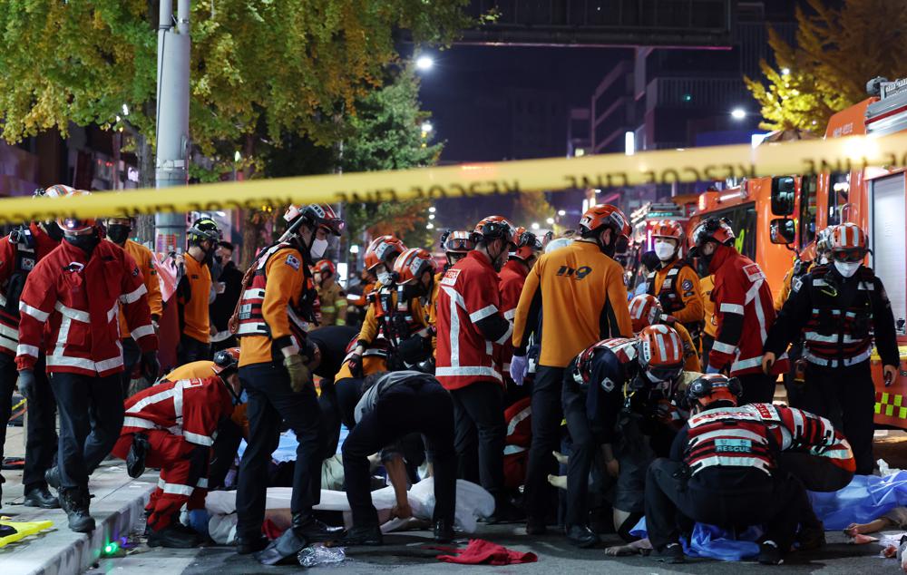 A crowd of first responders attending to those who were crushed in a stampede in South Korea that has killed dozens.