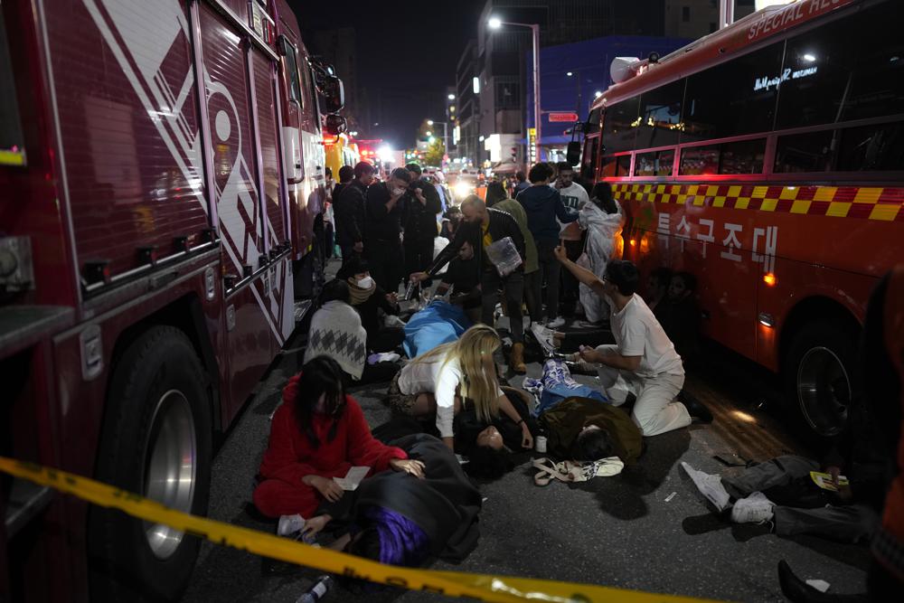 A crowd of first responders attending to those who were crushed in a stampede in South Korea that has killed dozens.