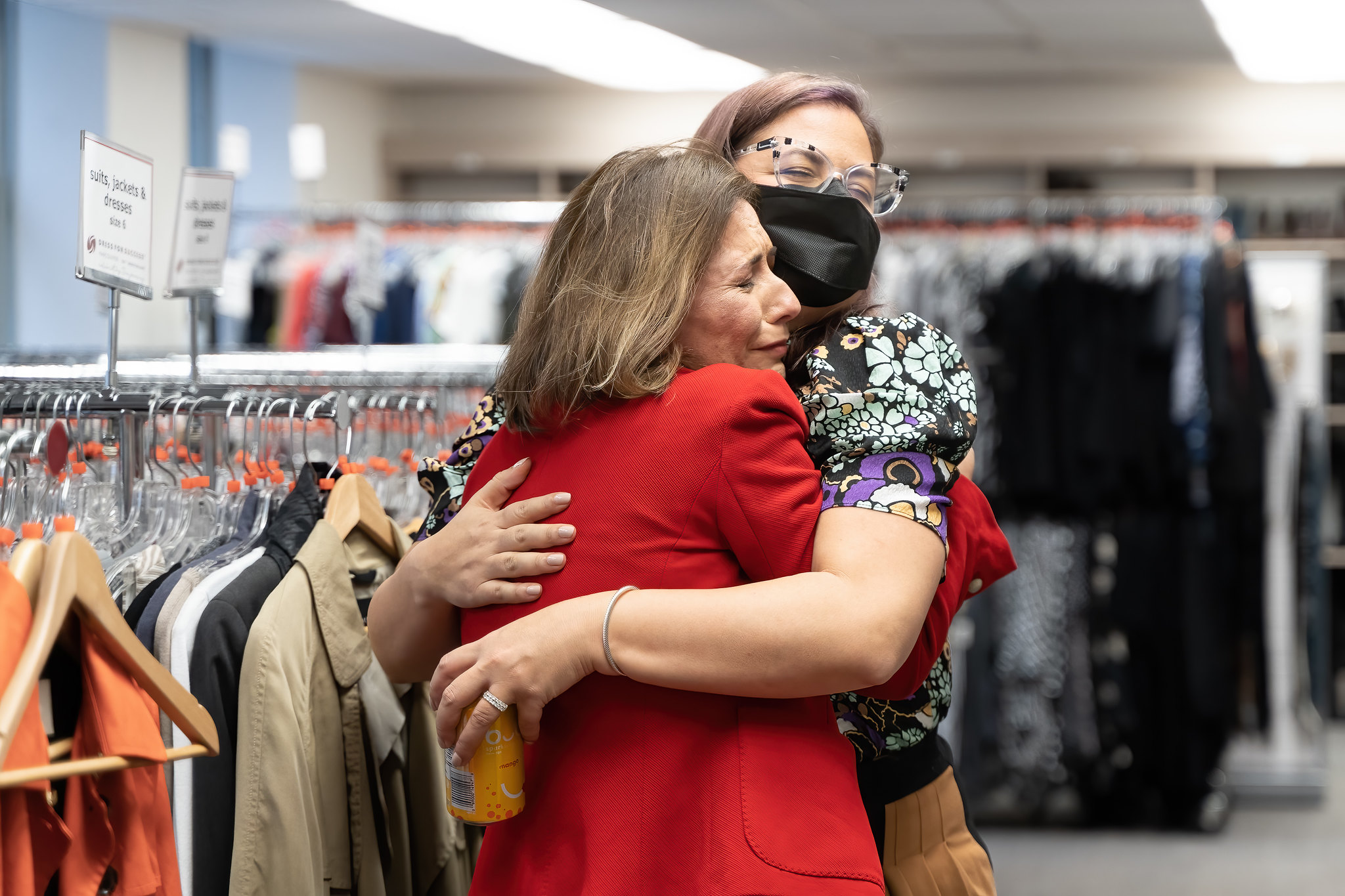 A Dress for Success Vancouver volunteer hugs a client who is being dressed for a job interview