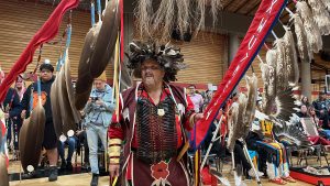 man stands in the centre of the room with traditonal indigenous items