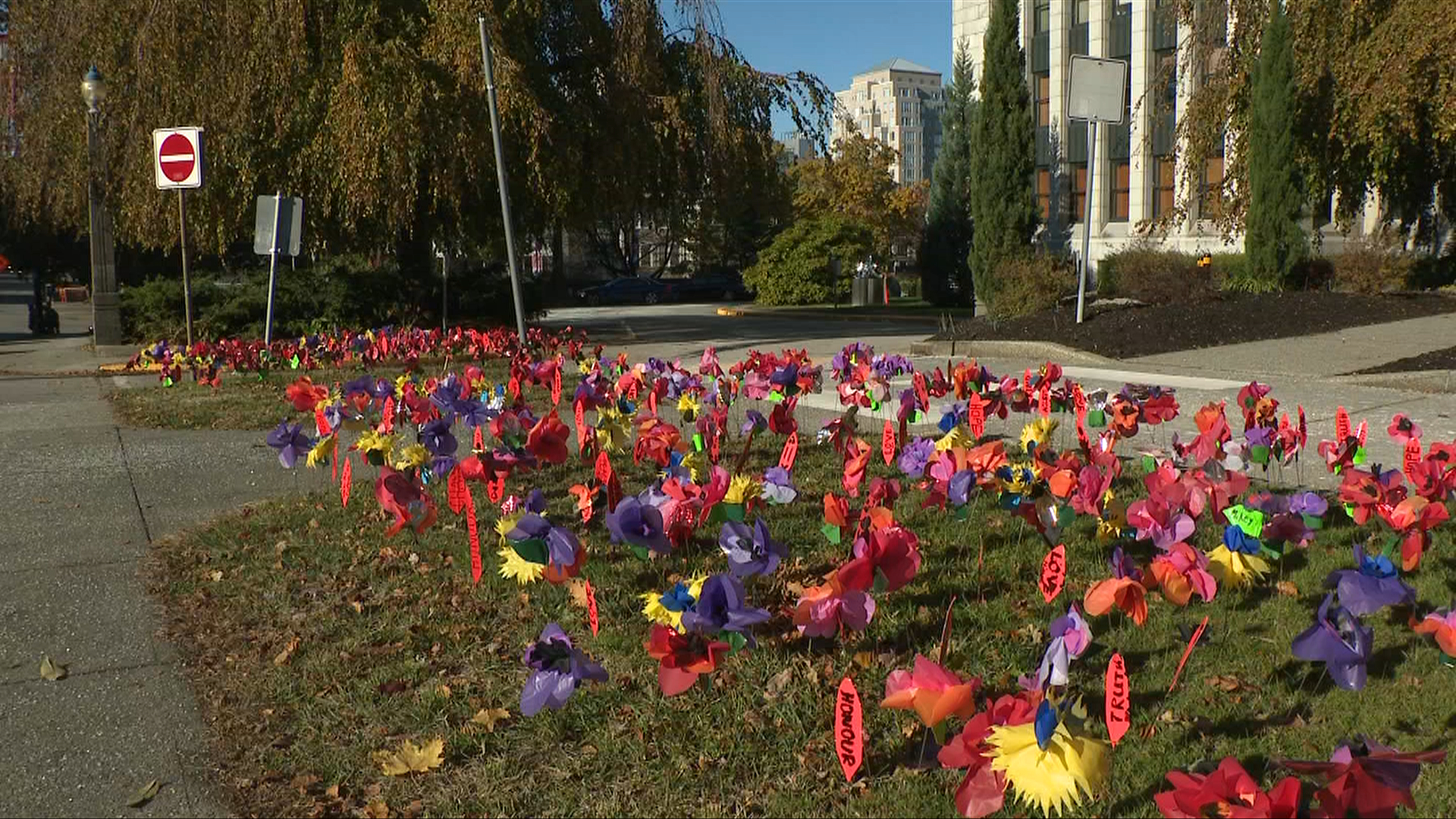 Remembrance Day poppies of different colours and feathers are placed on the grounds of Vancouver City Hall in honour of those who served Canada