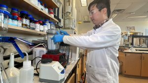 man stands in front of blender in lab coat