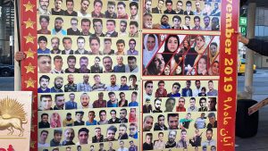tons of pictures of people pasted on a wall like structure