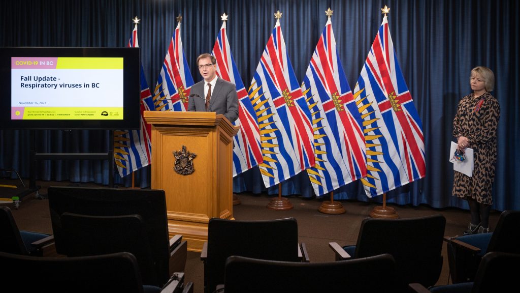 Adrian Dix speaks at a podium with Dr. Bonnie Henry at the side