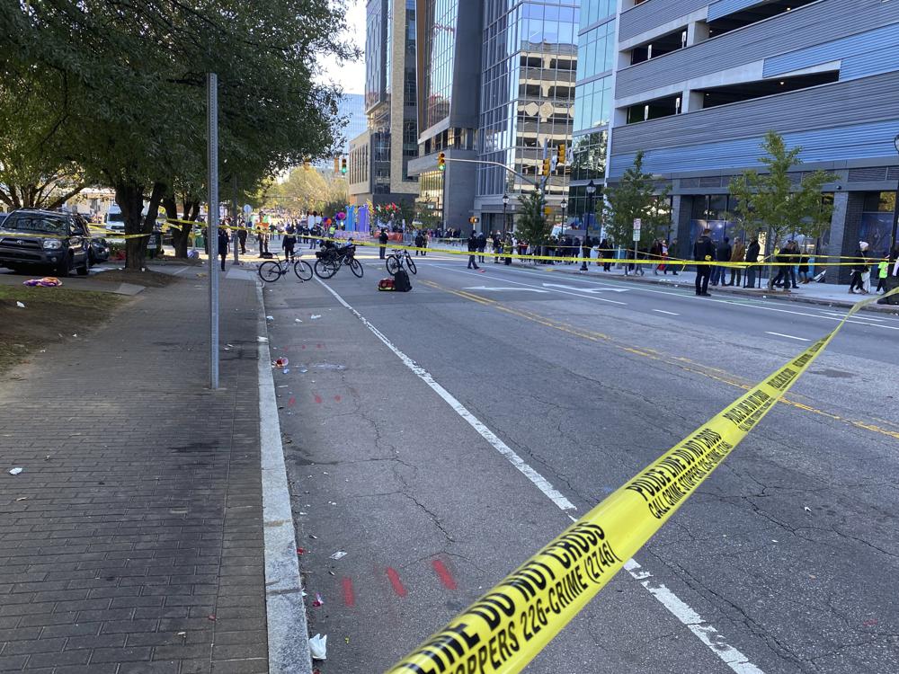 Police officers work the scene after a truck pulling a float crashed at a holiday parade in Raleigh, N.C., on Saturday, Nov. 19, 2022. Witnesses say people attending the Raleigh Christmas Parade heard the truck's driver screaming that he had lost control of the vehicle and couldn’t stop it before the crash.