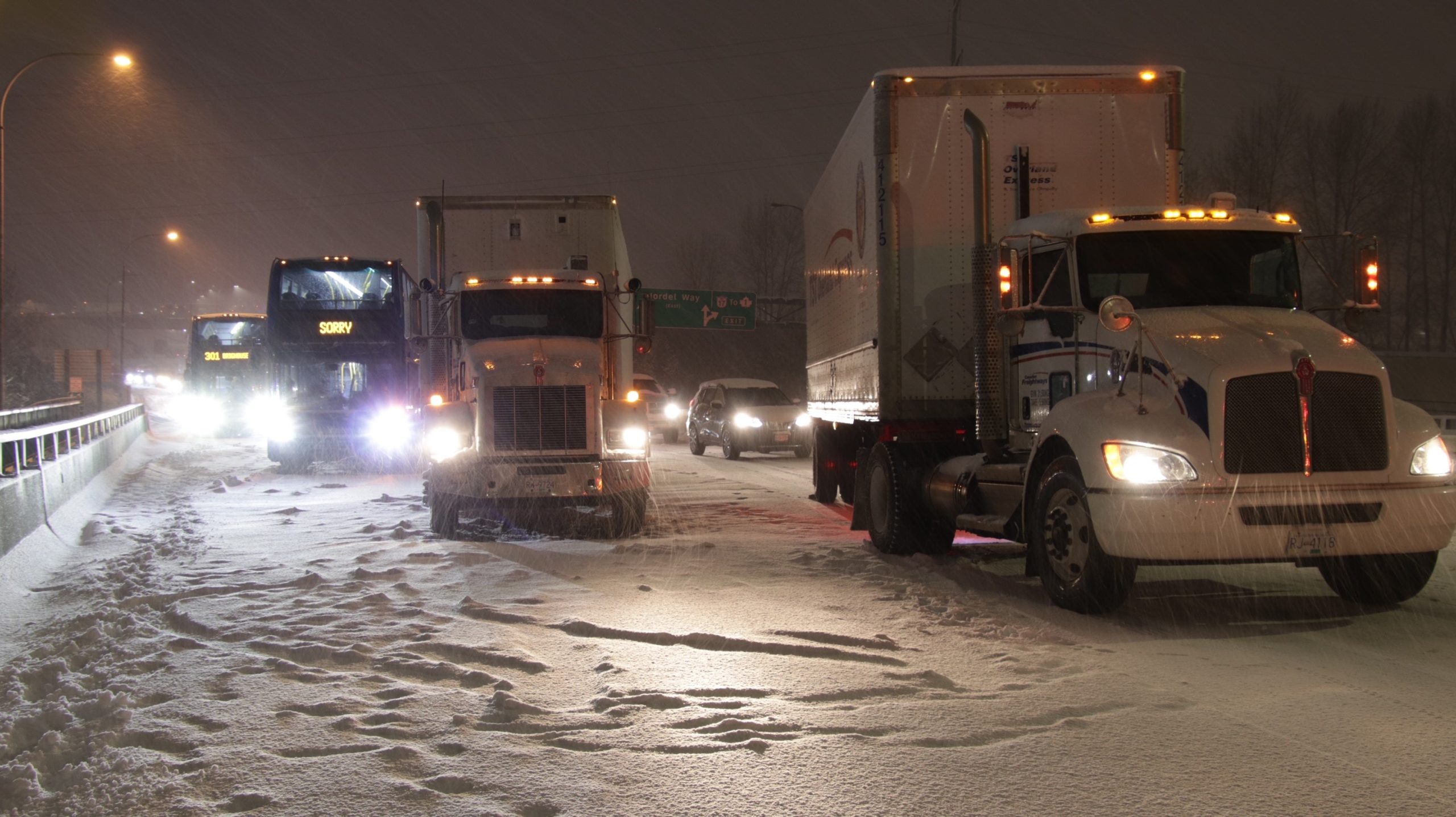 Trucks and other vehicles on snow-covered roads amid major gridlock following a storm in Metro Vancouver